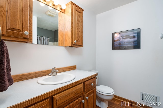 bathroom with vanity, hardwood / wood-style floors, toilet, and walk in shower