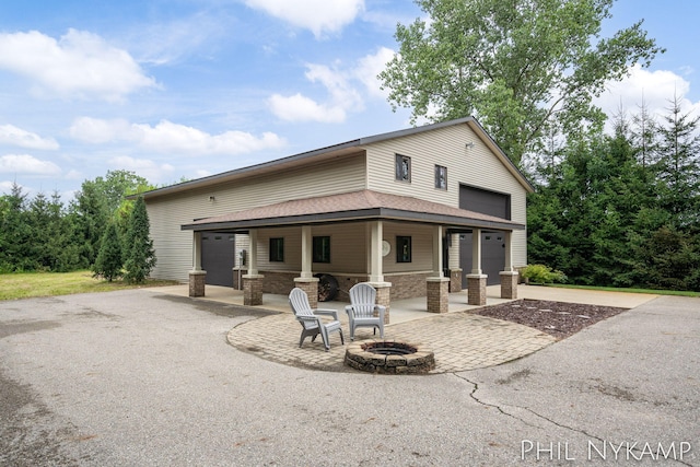 rear view of house featuring an outdoor fire pit and a patio area