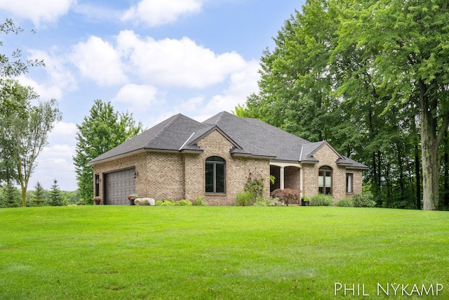 french country home featuring a garage and a front lawn