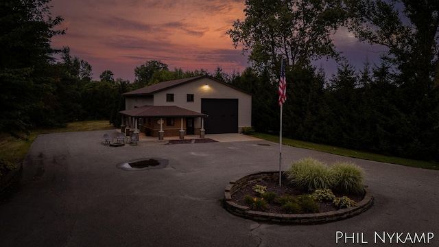 view of front of home with a garage, an outdoor structure, and a porch