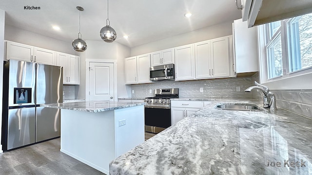 kitchen with a kitchen island, white cabinetry, appliances with stainless steel finishes, and sink