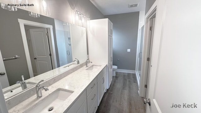 bathroom featuring a shower with door, wood-type flooring, vanity, and toilet