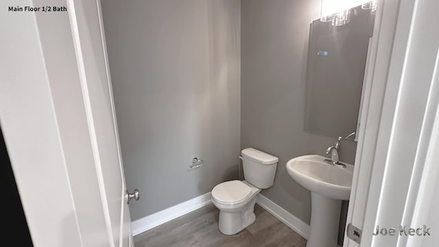 bathroom with sink, toilet, and hardwood / wood-style floors