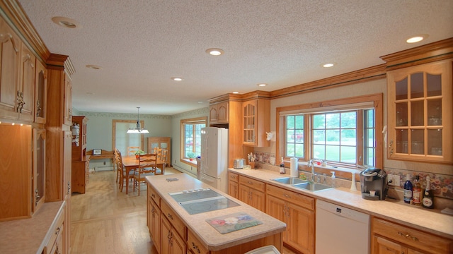 kitchen featuring pendant lighting, sink, a center island, crown molding, and white appliances