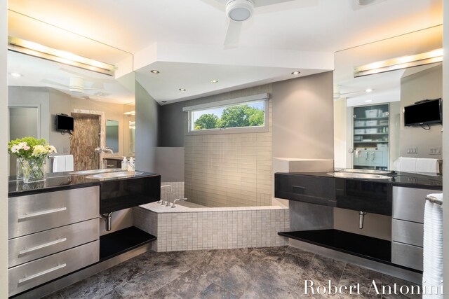 bathroom featuring ceiling fan, tiled bath, and vanity