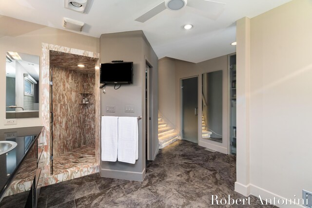 bathroom with vanity, ceiling fan, and a tile shower