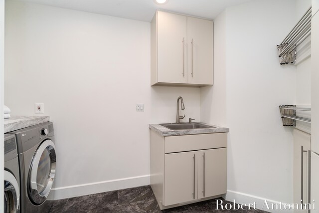 washroom with washer and dryer, cabinets, and sink