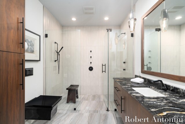 bathroom featuring vanity and a shower with door