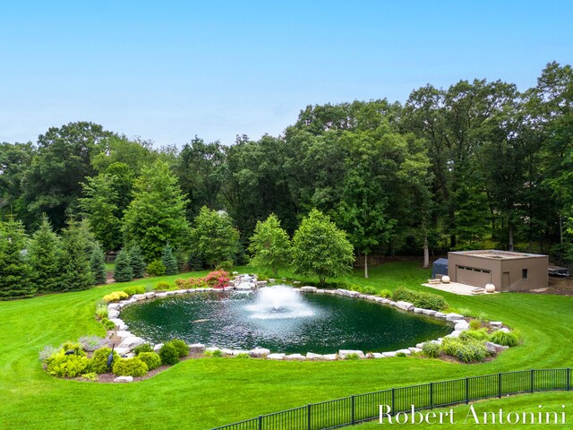 view of property's community with a water view and a lawn