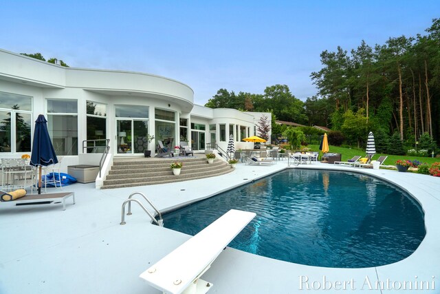 view of pool featuring a diving board and a patio area