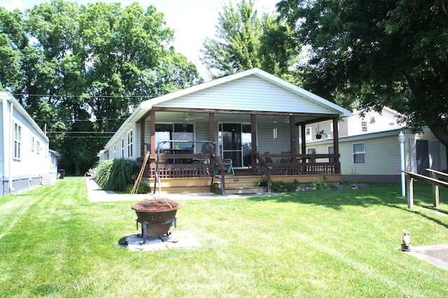 bungalow-style house with a porch, a fire pit, and a front lawn