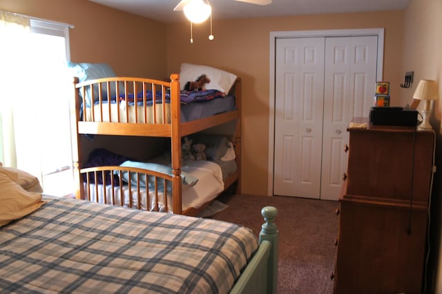 carpeted bedroom featuring ceiling fan and a closet