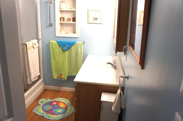 bathroom featuring vanity, an enclosed shower, and hardwood / wood-style flooring