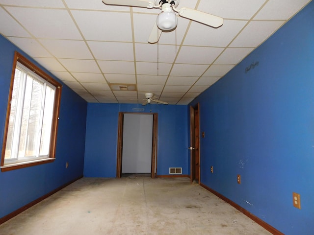 empty room featuring a paneled ceiling, light colored carpet, and ceiling fan