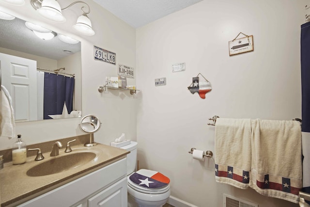 bathroom with vanity, a textured ceiling, and toilet