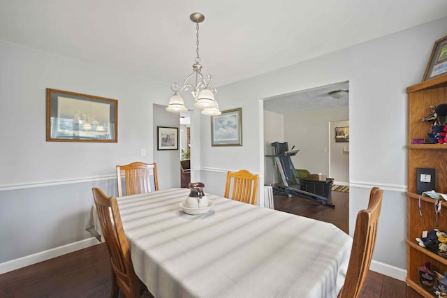 dining area featuring dark hardwood / wood-style floors and a notable chandelier