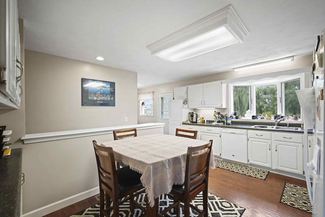 dining space featuring dark hardwood / wood-style floors, sink, and a wealth of natural light