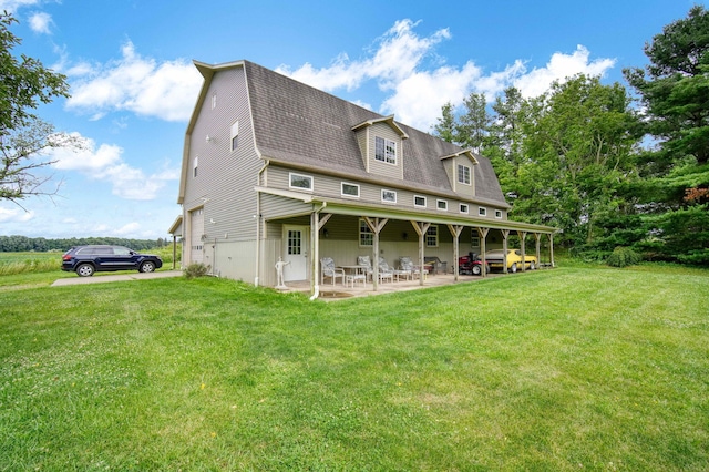 back of house with a lawn and a patio area