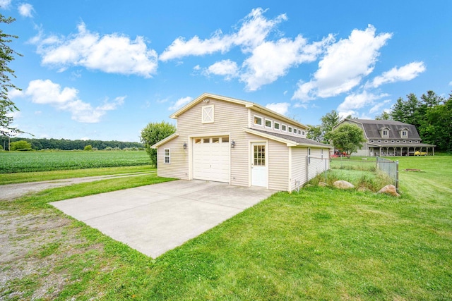 garage with a rural view and a lawn