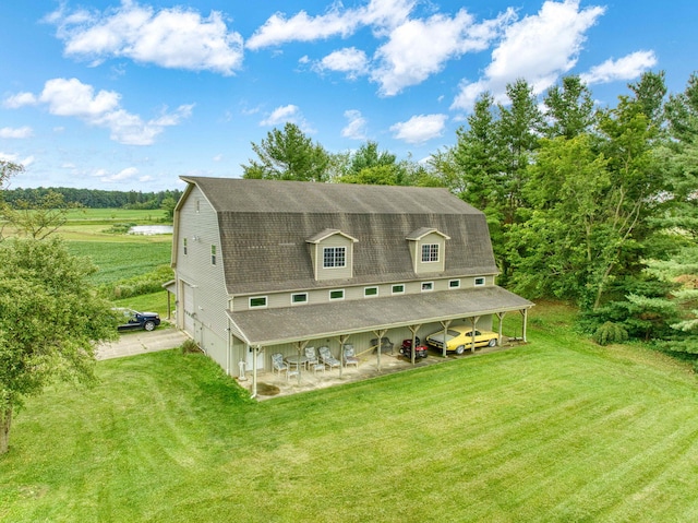 rear view of house featuring a rural view, a yard, and a carport