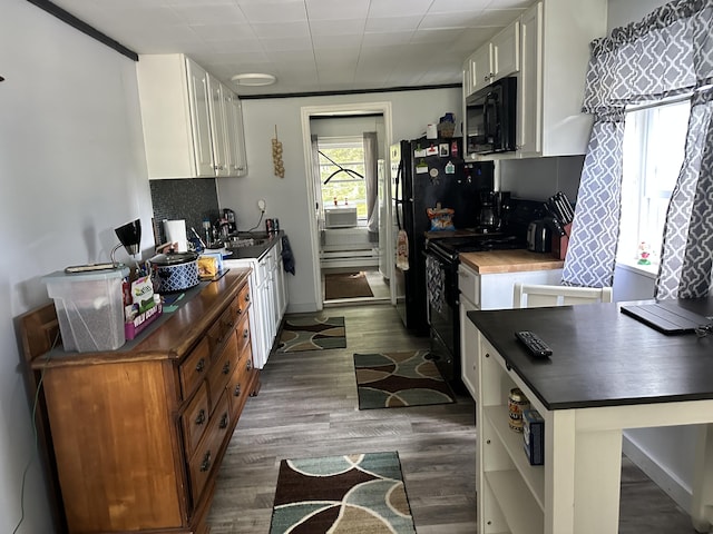 kitchen featuring sink, tasteful backsplash, dark hardwood / wood-style flooring, black range with electric stovetop, and white cabinets