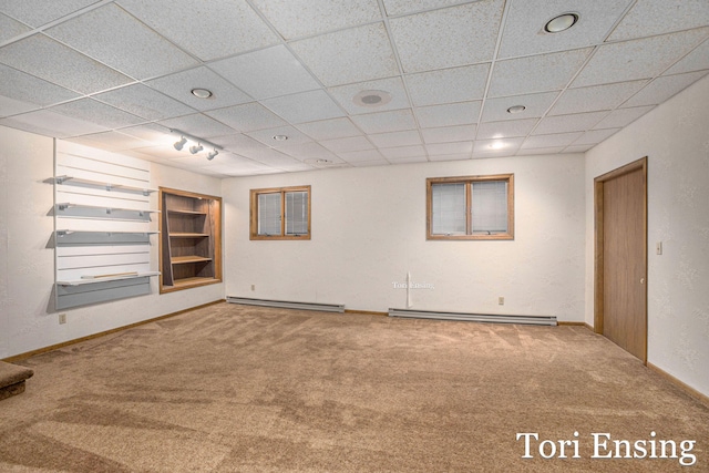 empty room with carpet and a baseboard heating unit