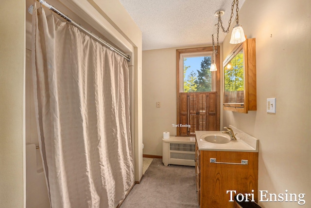 bathroom with vanity, radiator, toilet, and a textured ceiling