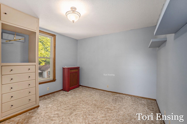 unfurnished bedroom featuring light carpet and a textured ceiling