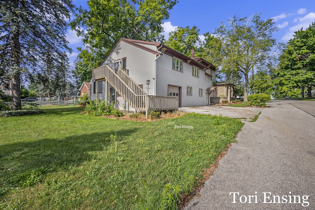 view of side of home featuring a garage and a yard