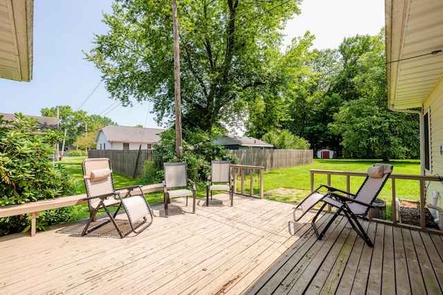 deck featuring a storage shed and a lawn