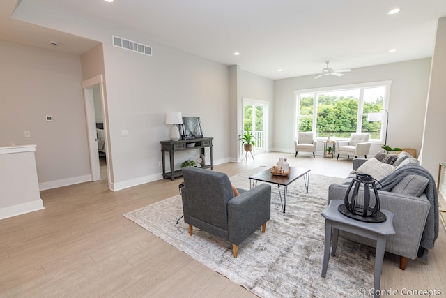 living room with light hardwood / wood-style flooring and ceiling fan