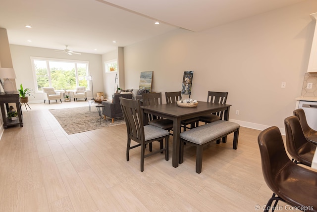 dining space with ceiling fan and light wood-type flooring