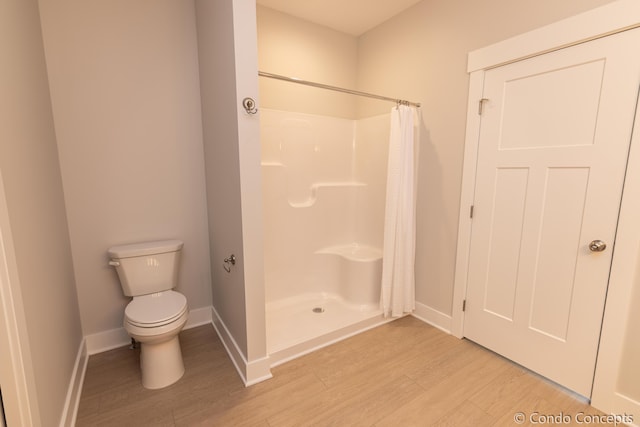 bathroom with toilet, hardwood / wood-style floors, and a shower with curtain