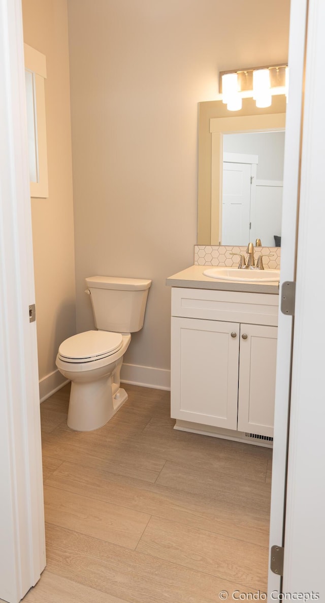 bathroom featuring vanity, hardwood / wood-style floors, and toilet