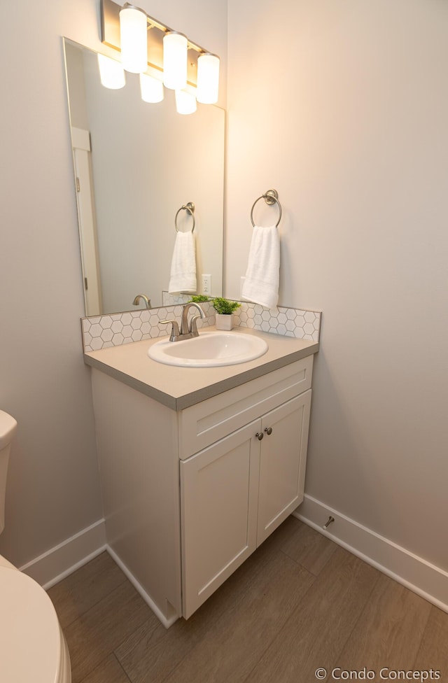 bathroom featuring hardwood / wood-style flooring, vanity, and toilet