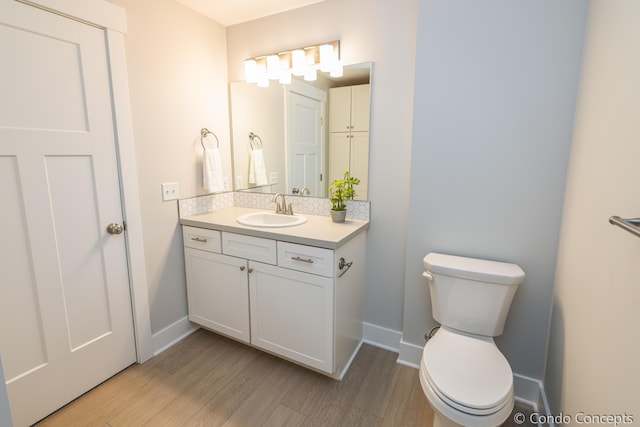 bathroom with wood-type flooring, vanity, and toilet