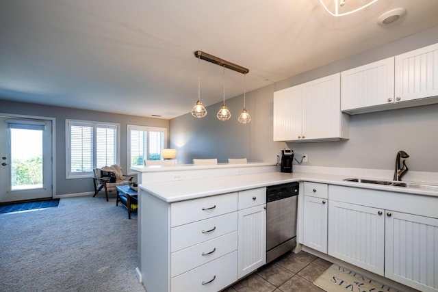 kitchen with hanging light fixtures, sink, stainless steel dishwasher, and kitchen peninsula