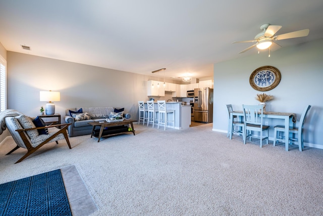 carpeted living room with ceiling fan