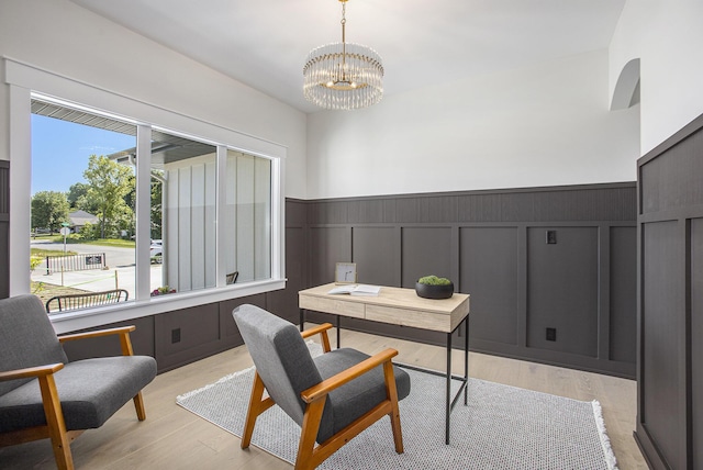 home office featuring a notable chandelier and light hardwood / wood-style flooring