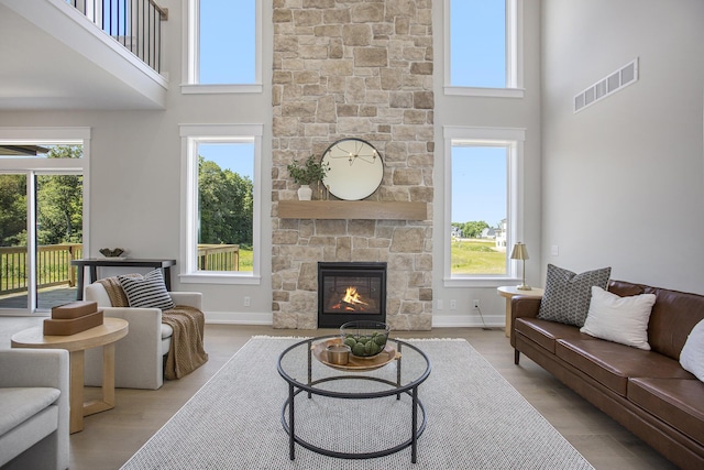 living room with a towering ceiling, plenty of natural light, and a fireplace