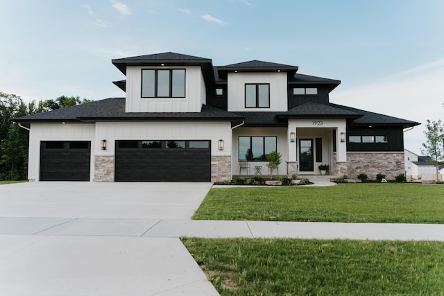 prairie-style home featuring a garage and a front lawn