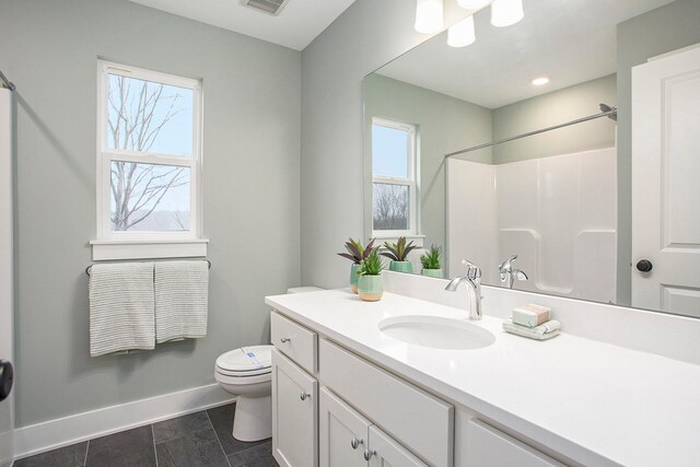 bathroom with a shower, vanity, toilet, and a healthy amount of sunlight