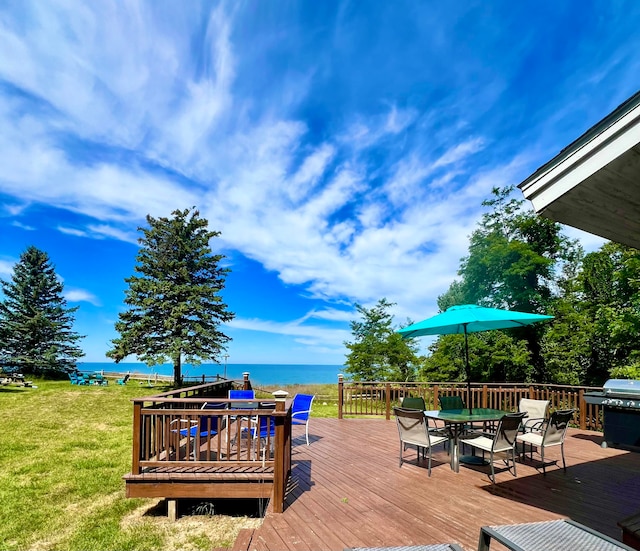 wooden terrace featuring a lawn and a water view