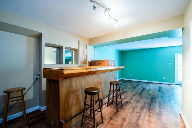 kitchen featuring a kitchen breakfast bar, butcher block counters, wood-type flooring, and kitchen peninsula