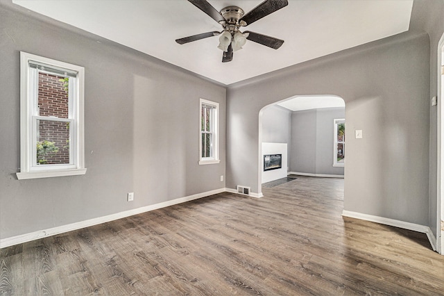 unfurnished living room with dark hardwood / wood-style floors and ceiling fan