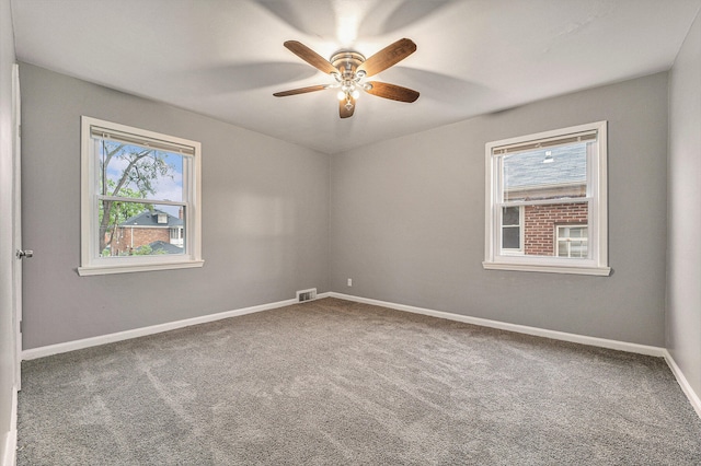 spare room featuring carpet flooring, ceiling fan, and plenty of natural light