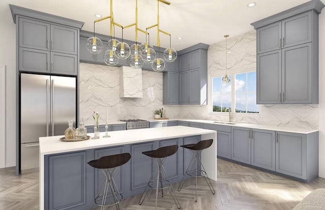 kitchen featuring stainless steel built in refrigerator, a kitchen breakfast bar, gray cabinets, and sink