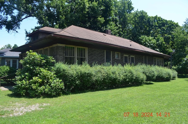 view of side of home with a yard