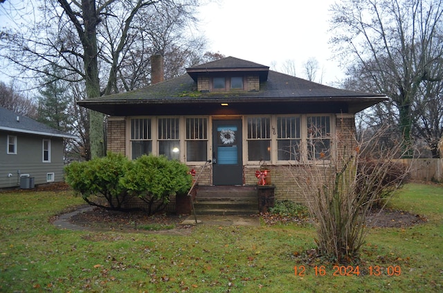 bungalow-style home featuring central AC unit and a front lawn