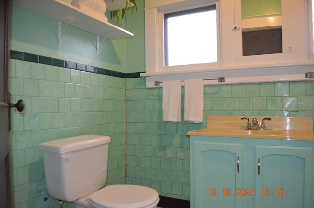 bathroom with decorative backsplash, vanity, toilet, and tile walls